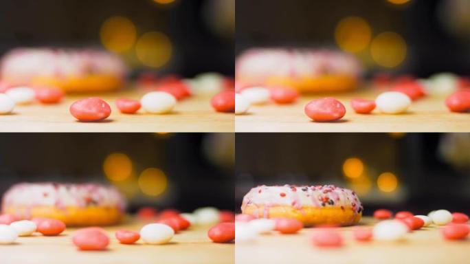 用糖果装饰的粉色甜甜圈。微距和滑块拍摄。釉面甜品。面包店和食品概念。各种彩色甜甜圈。4K，UHD巧克