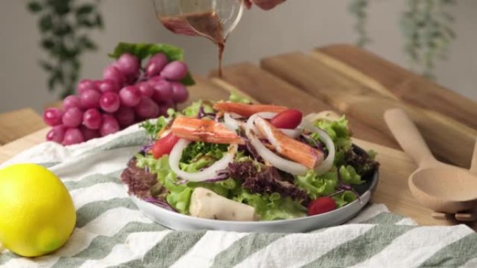 慢动作4k视频，用日本调料芝麻酱油倒沙拉。健康的意大利沙拉配西红柿、蘑菇、蔬菜、蟹棒和洋葱。新鲜食材
