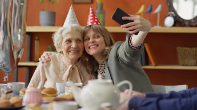 快乐的女人在生日晚宴上与奶奶自拍