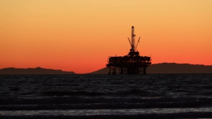 海上石油平台后面的太阳落山