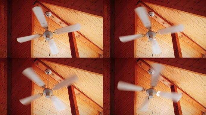 天花板上有风扇的吊灯。吊灯风扇在木制天花板上旋转。吊灯风扇运行