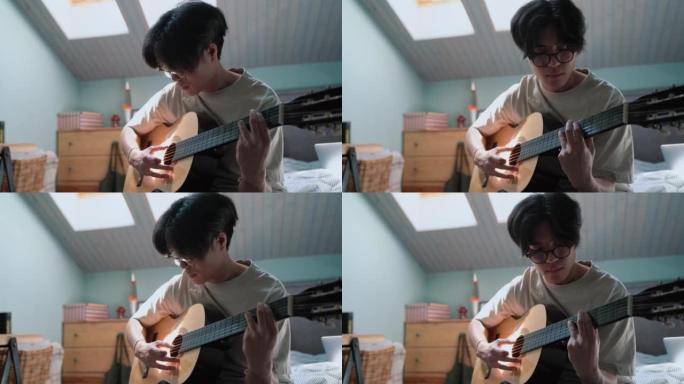漂亮的亚洲男人在床上弹吉他