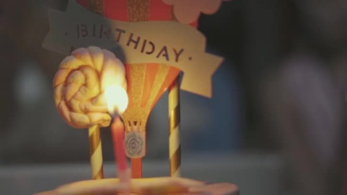 关闭4k的烛光和燃烧在美味的生日蛋糕与模糊的背景与孩子们与幸福显示的概念庆祝和派对周年活动和节日。