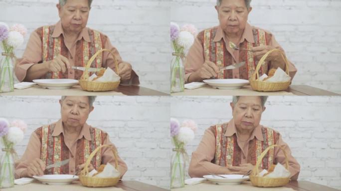 老年妇女吃脆皮土豆球炸丸子食品。成熟的退休生活方式