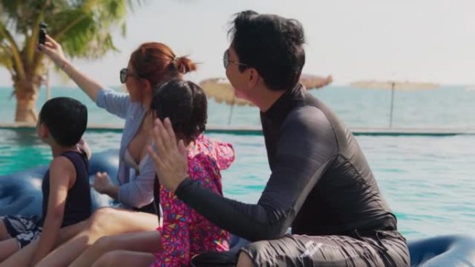 快乐的亚洲家庭一起玩耍进入游泳池，家庭，度假和旅行的概念。