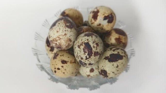 白底盘子里煮鹌鹑蛋。可以通过油炸或煮沸的方式食用。表面上有斑点的棕色。在印度尼西亚被称为telur 