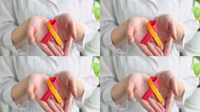 世界肝炎日。女人医生手里拿着红色的黄色丝带。预防和治疗病毒性肝炎的意识。肝癌。世界癌症日。全高清