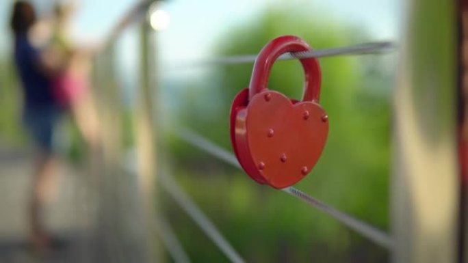 栏杆上挂着心形的红色婚礼锁。世界各地阻碍锁的婚礼传统。婚礼当天的纪念碑。锁上的铭文建议和爱