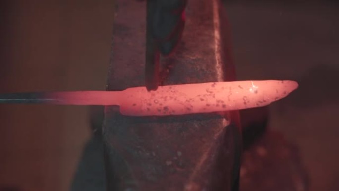 铁匠在铁匠车间手工锻造熔融金属。大马士革钢刀。