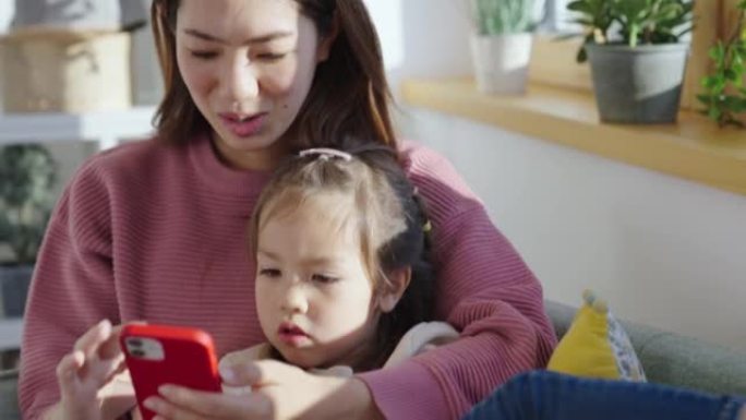 妈妈和可爱的小女儿一起用手机看动画片