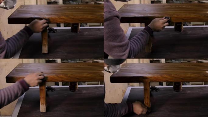 木匠在木桌上涂上保护性亚麻籽油的特写镜头