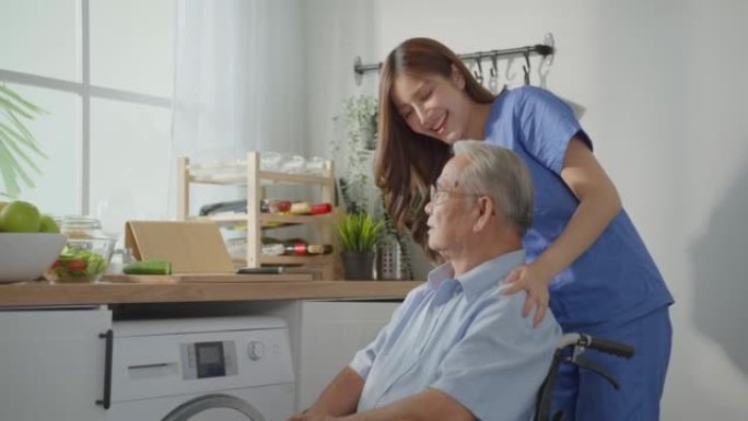 亚洲年轻女性照顾者坐在轮椅上照顾老年男性。老年成熟男子病人在家里用迷人的美丽的医学治疗师女从业者做物