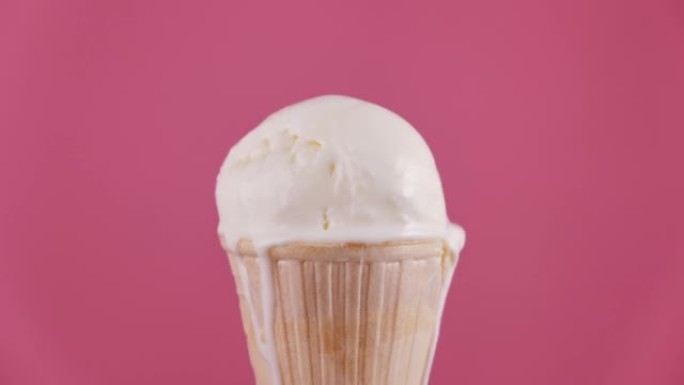 香草冰淇淋在华夫饼筒融化在粉红色背景。甜点