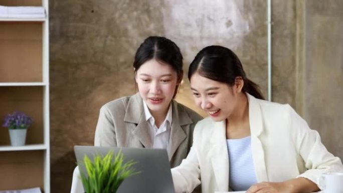 两名女性表现出喜悦，看着笔记本电脑上的数据，两名商界女性看着超过销售目标并实现盈利增长的月度销售总结