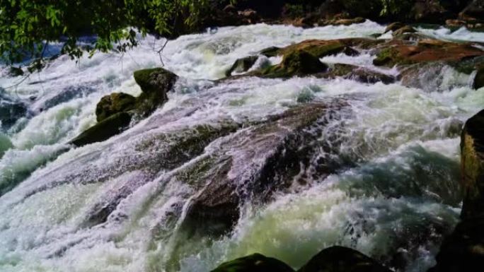 贵州黄果树瀑布国家公园大量苔藓的石头上的水冲