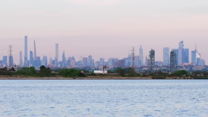 春季黄昏期间的曼哈顿天际线，取自Nj公园，由树木水和自然组成