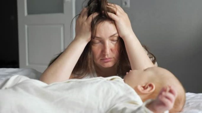 疲倦的母亲照顾新生女孩试图忽略头痛