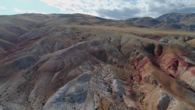 俄罗斯阿尔泰地区美丽的彩虹山脉的空中轨道视图。称为火星的地质构造。由于矿物的沉积，砂岩山链被多色图案