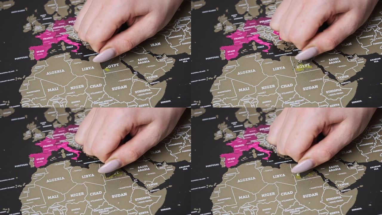 女性手在划伤世界地图表面划伤埃及国家