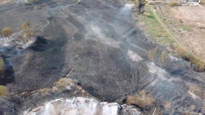 空中无人机在燃烧的山坡上飞行，浓浓的白烟被吹走。极端高温和气候变化导致的自然灾害