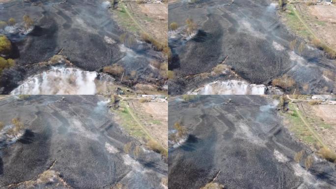 空中无人机在燃烧的山坡上飞行，浓浓的白烟被吹走。极端高温和气候变化导致的自然灾害