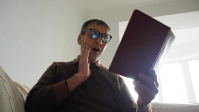 印度老人戴着眼镜在家看书，吓得休克惊讶