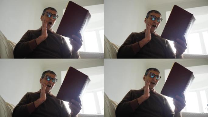 印度老人戴着眼镜在家看书，吓得休克惊讶
