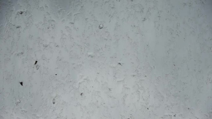 在特写镜头中，雨滴从肮脏的窗户流下。