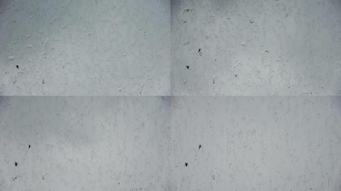 在特写镜头中，雨滴从肮脏的窗户流下。