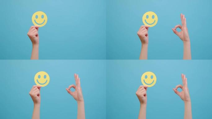女性手捧着黄色的幸福笑脸，良好的反馈评分和积极的客户评价，显示ok标志，满意度调查，精神卫生评估，孤