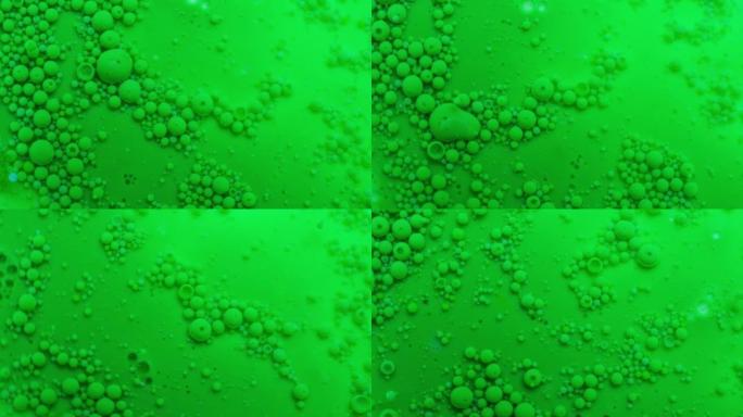 两种不溶性介质。不寻常的抽象绿色背景与许多小滴。平稳的运动。失重和表面张力。实验实验室