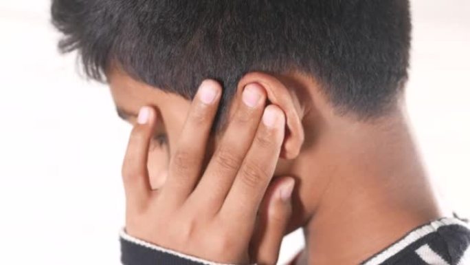 十几岁的男孩耳朵疼痛触摸他痛苦的耳朵，