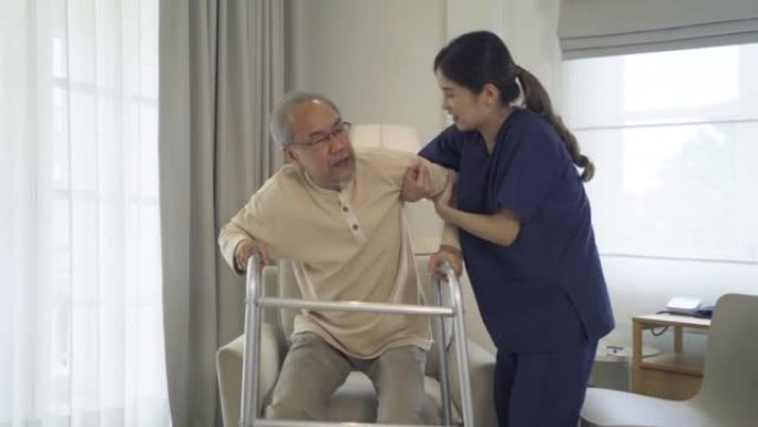 亚洲女护士，女儿帮助父亲从椅子上站起来，在家里的卧室或医疗保健中支持老年老年患者。人们的生活方式。家