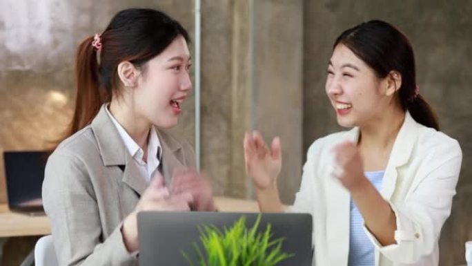两名女性表现出喜悦，看着笔记本电脑上的数据，两名商界女性看着超过销售目标并实现盈利增长的月度销售总结