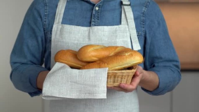 用烤法式长棍面包和亚麻毛巾手握篮子。面包。面包店