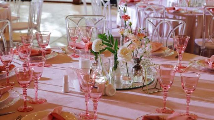 一张漂亮的节日餐桌，配有眼镜、盘子和标有餐桌号码的标牌。平稳的摄像机运动