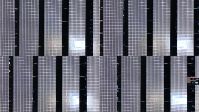 太阳能电池板的鸟瞰图安装在停车场的遮阳屋顶上，停放的汽车可以有效地产生清洁的电力。光伏技术集成在城市