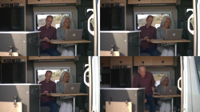 退休夫妇在定制露营车中使用笔记本电脑