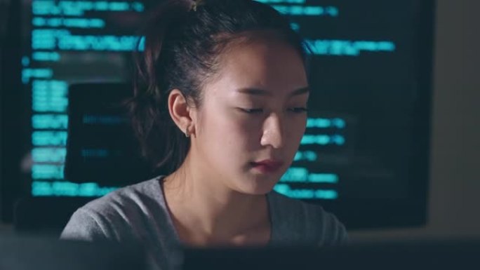 年轻的亚洲女性，开发程序员，软件工程师，IT支持，晚上加班在计算机上工作，以检查错误系统和运行程序中