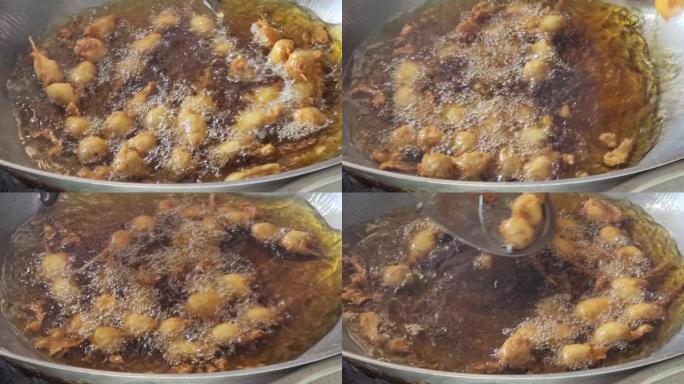 泰国街头食品用平底锅里的油煎炸肉球香肠棒。