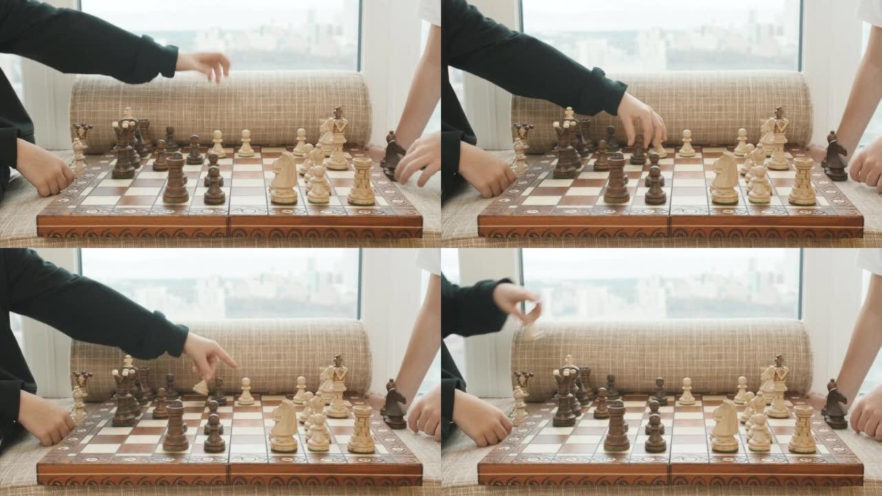 下棋的特写。创意。在国际象棋比赛中做出动作的孩子的手，棋盘上的木块。