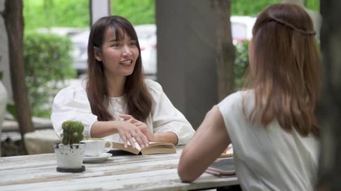 年轻女性在咖啡店喝咖啡时愉快地交谈。