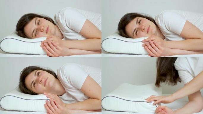 一个女人用记忆泡沫制成的矫形枕头起床，枕头呈以前的形状