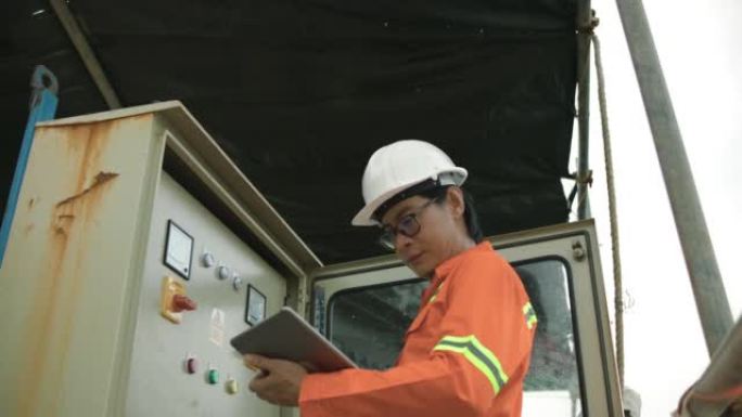 年轻的男性工程师用平板电脑检查机器。