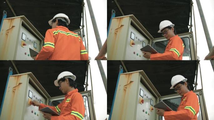 年轻的男性工程师用平板电脑检查机器。