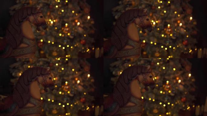 圣诞气氛。老式木制马椅秋千在圣诞节晚上摇摆，背景是圣诞树。舒适的假日氛围