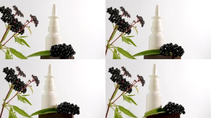 白色背景上有黑色浆果的鼻腔喷雾，顺势疗法治疗，基于接骨木浆果的医用鼻腔喷雾在桌子上旋转