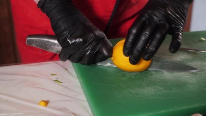厨师在厨房的烹饪板上用刀切黄柠檬。用刀煮手切多汁成熟的柠檬做饭。