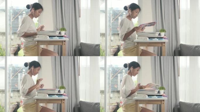 亚洲女孩在家做作业或在靠近窗户的桌杠上写书，教育生活方式理念。