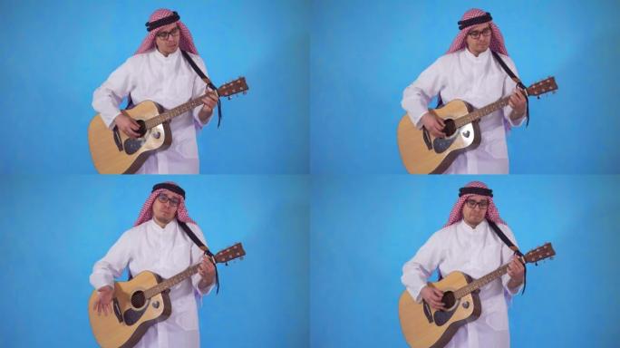 戴眼镜的阿拉伯男人笨拙地在蓝色背景上弹奏原声吉他